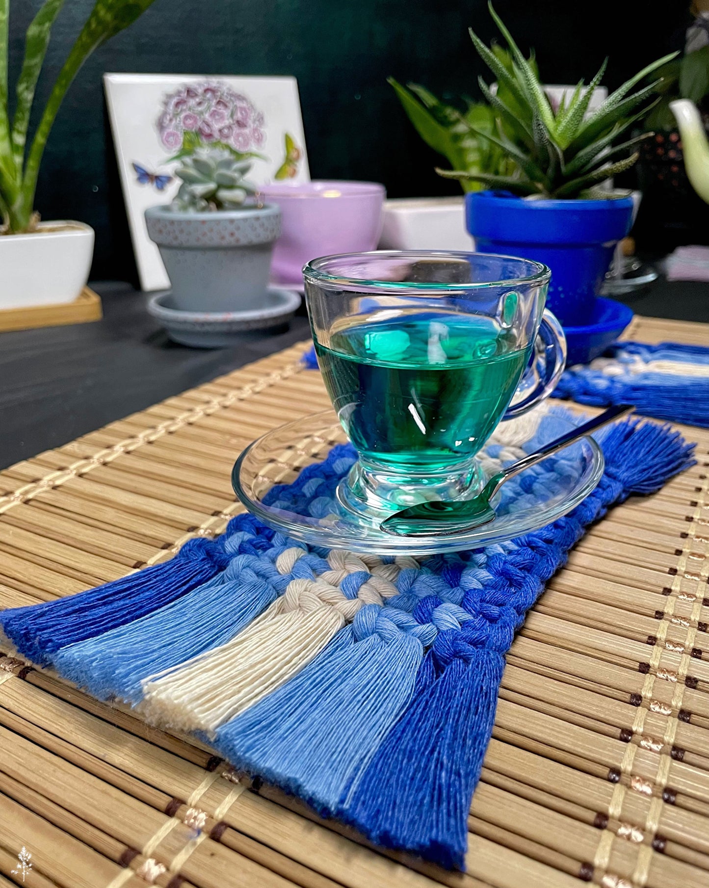 Glass of green liquid on a macrame coaster with decorative elements