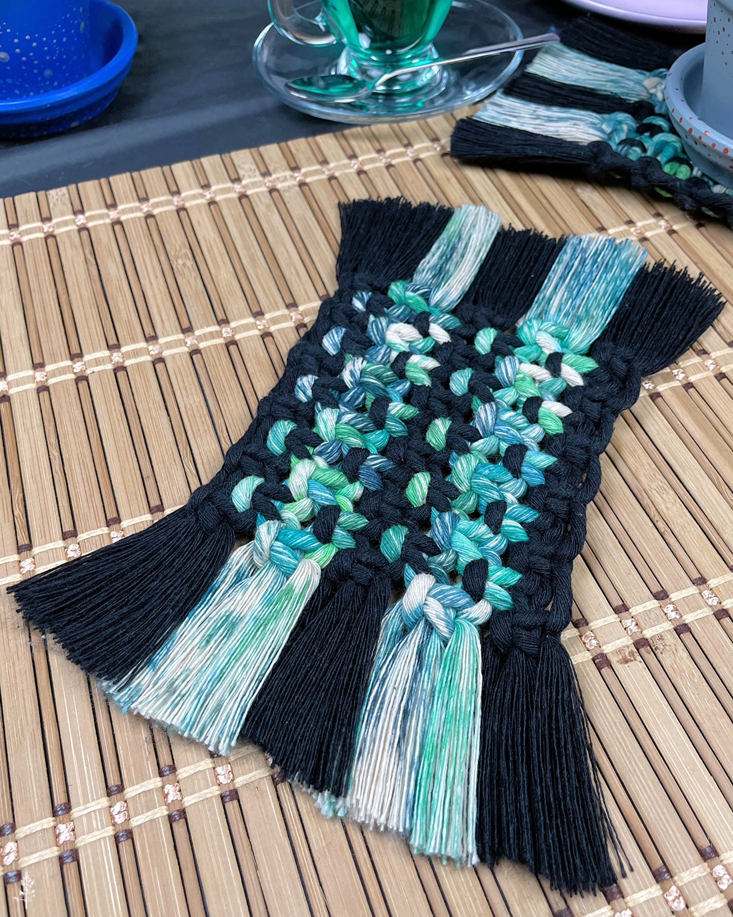 Macrame coaster in black and tie dyed green cotton rope